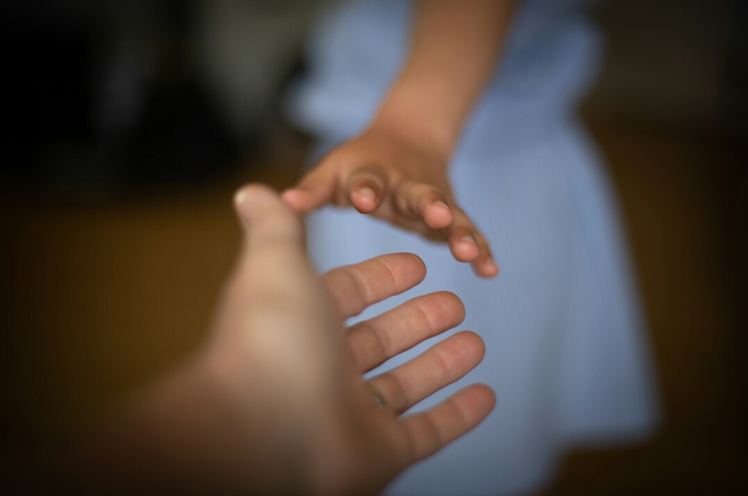 Business negotiation handshake across a conference table